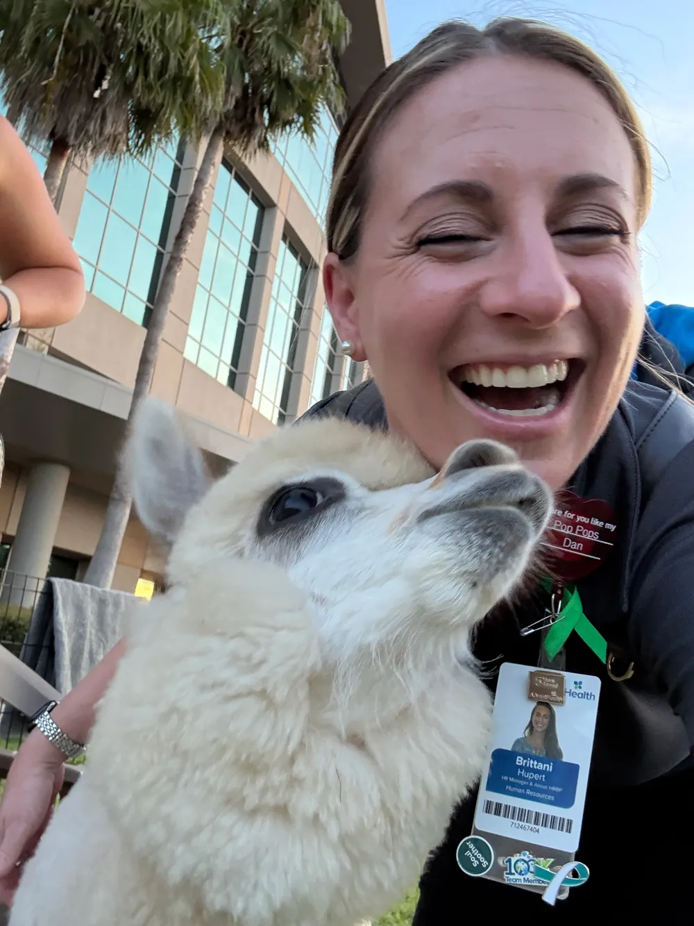 A selfie AdventHealth Team Member smiling with an alpaca