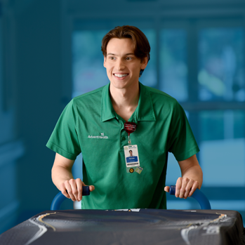 A smiling male AdventHealth transportation worker