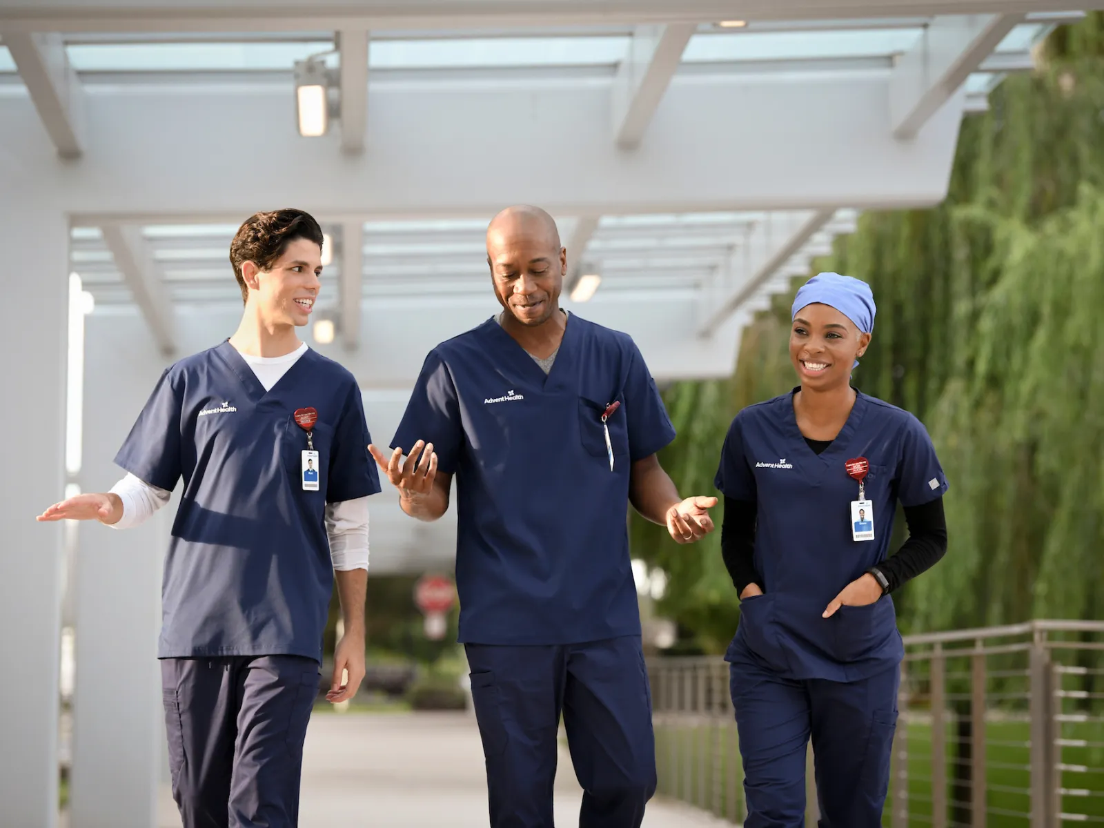 3 nurses walking outdoor corridor