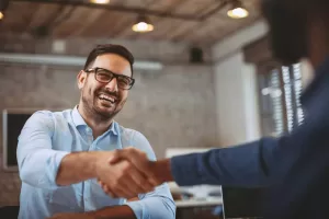 A man gives a handshake to the interviewer at a job interview
