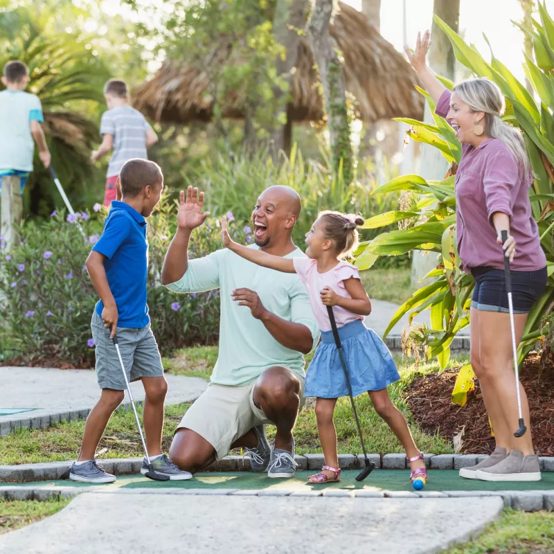 A Family Congratulates Their Son For Winning at Putt Putt Golf.