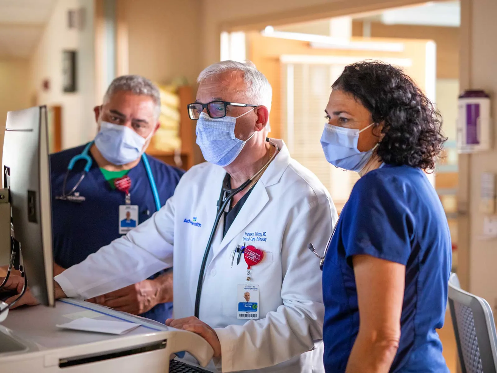 A doctor and his nurse assistants on a computer