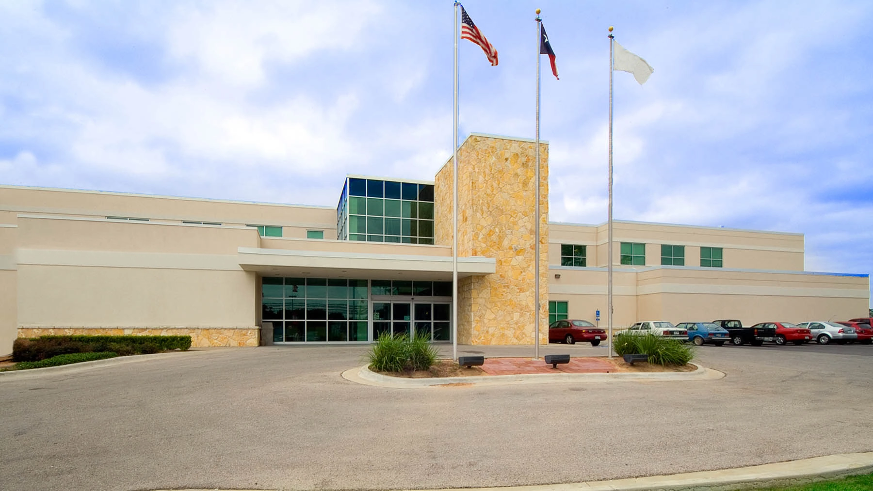 Exterior of AdventHealth Rollins Brook hospital with main entrance and flagpoles.