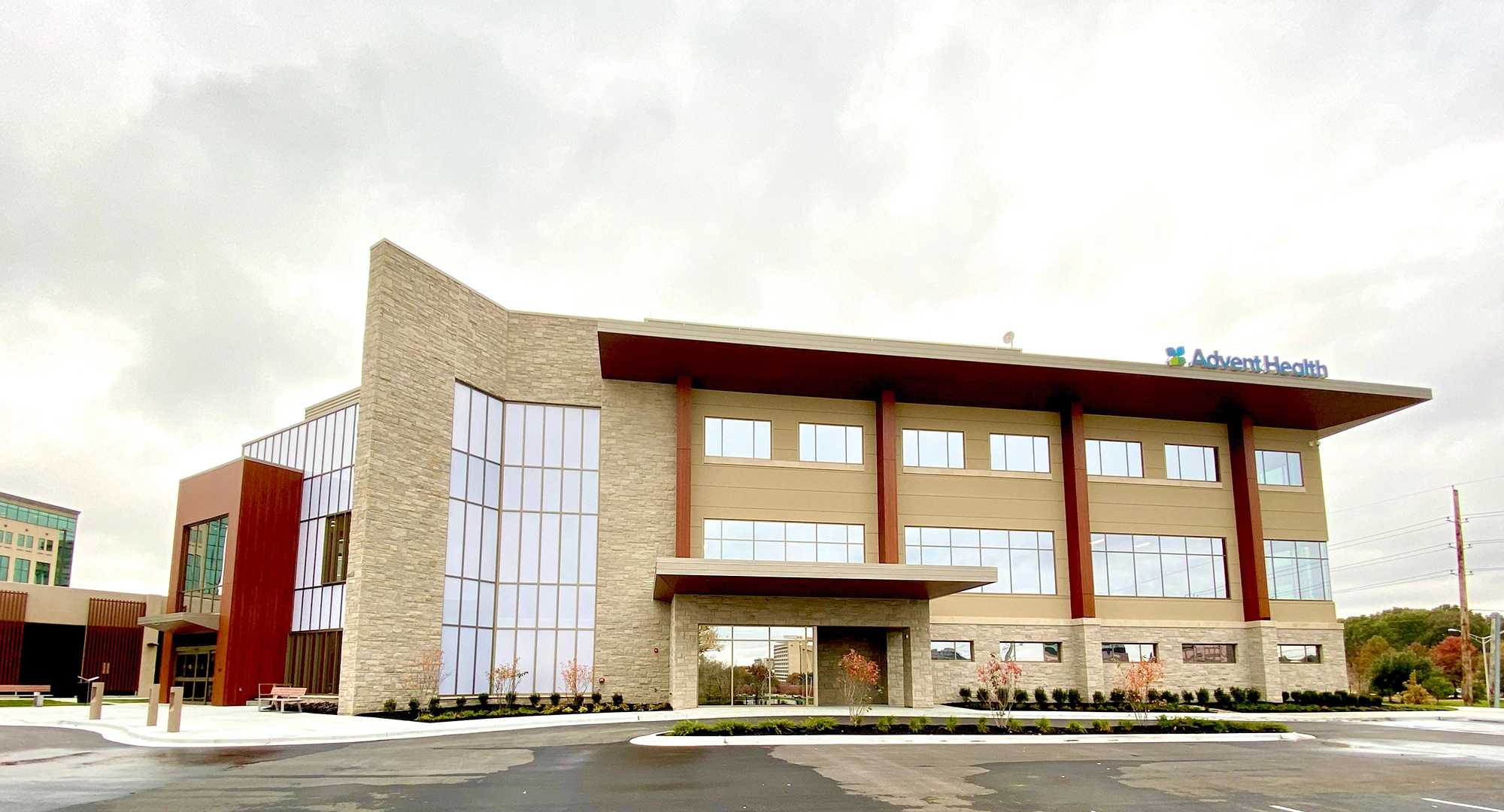 Exterior of AdventHealth College Boulevard facility with modern stone and glass façade.