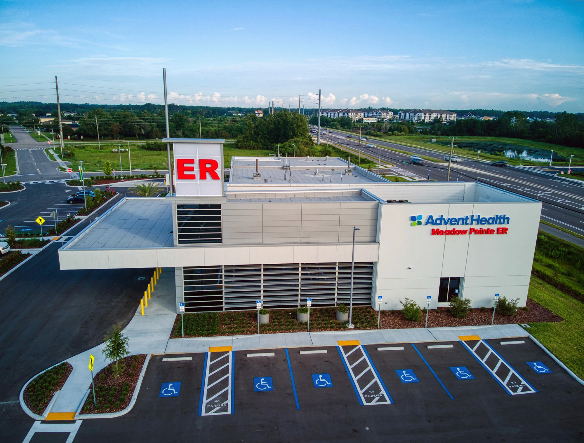 Exterior of AdventHealth Meadow Pointe ER with building signage and emergency tower.