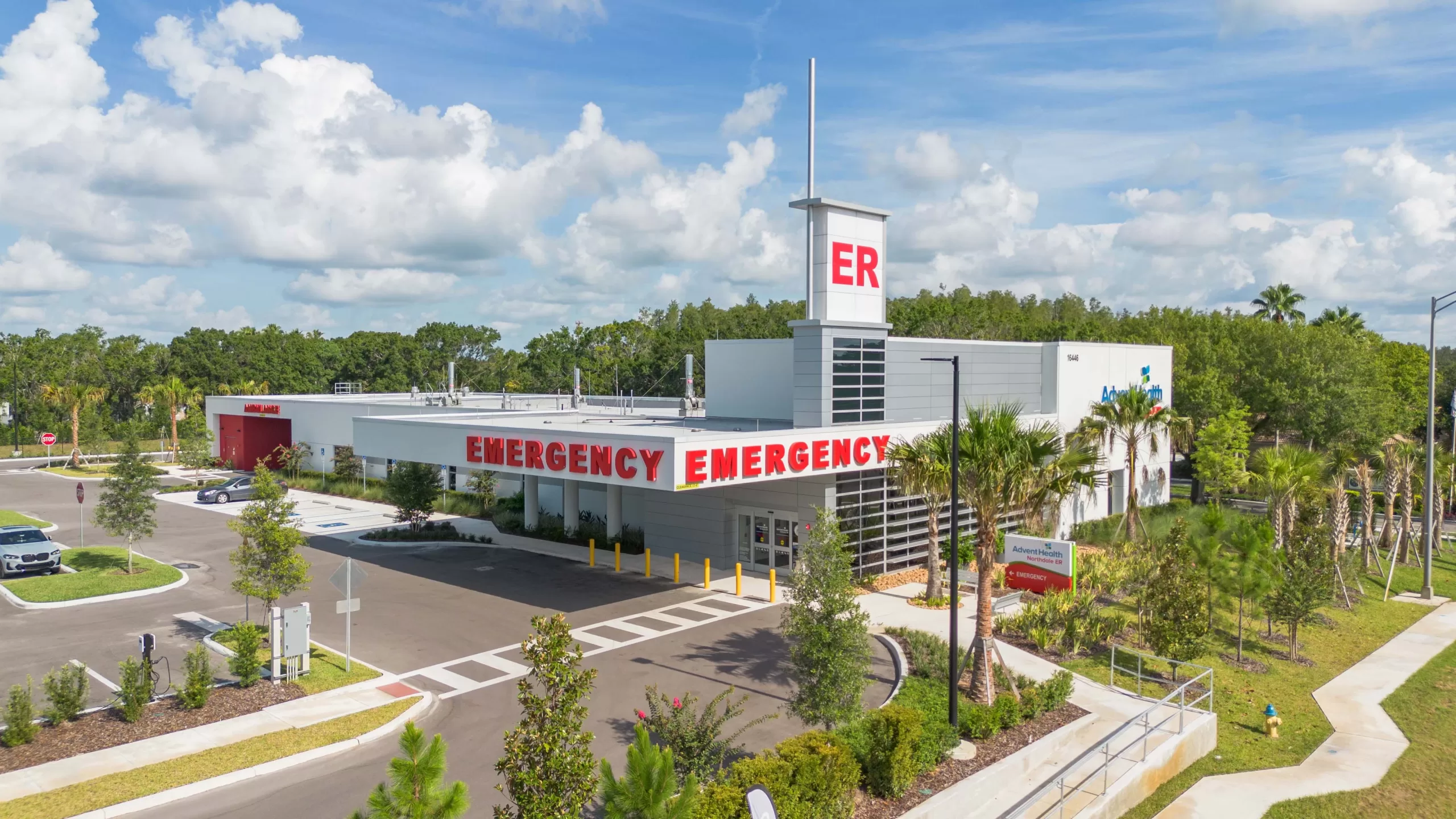 Aerial exterior view of AdventHealth Northdale emergency room featuring red emergency signage, ER tower, and landscaped entrance.