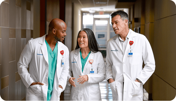 A diverse group of three physicians collaborating in a hospital corridor