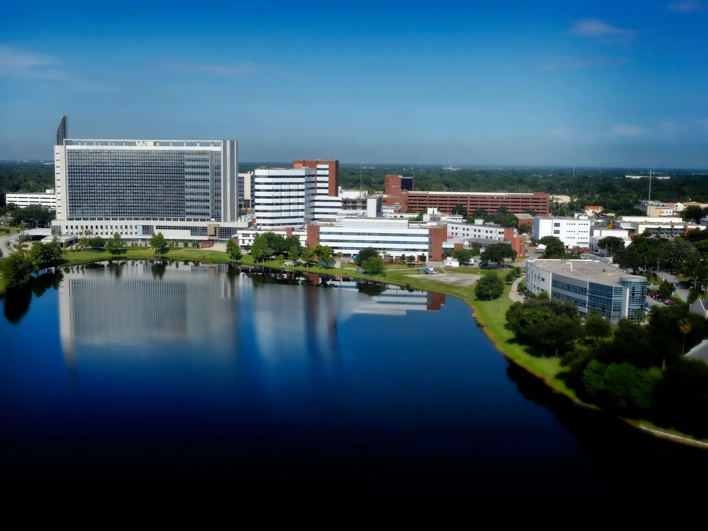 Aerial view of AdventHealth Orlando hospital campus and surrounding lake in Orlando, Florida.