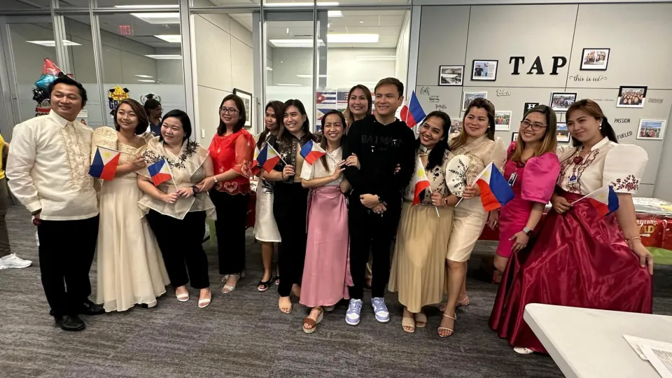 Filipino TAP graduates wearing traditional Filipino clothes and holding Filipino flags