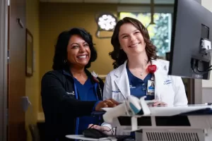 Nurse and physician reviewing information together at a computer workstation.