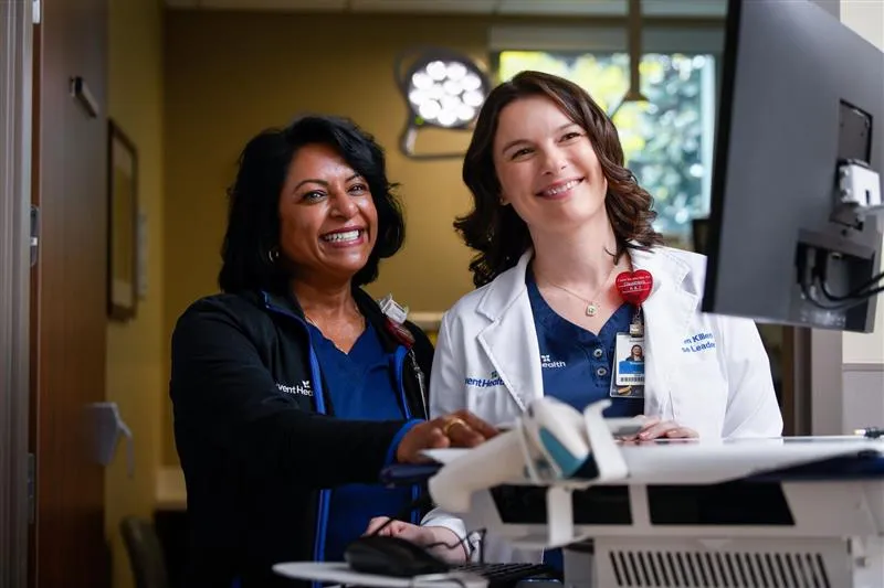 Nurse and physician reviewing information together at a computer workstation.